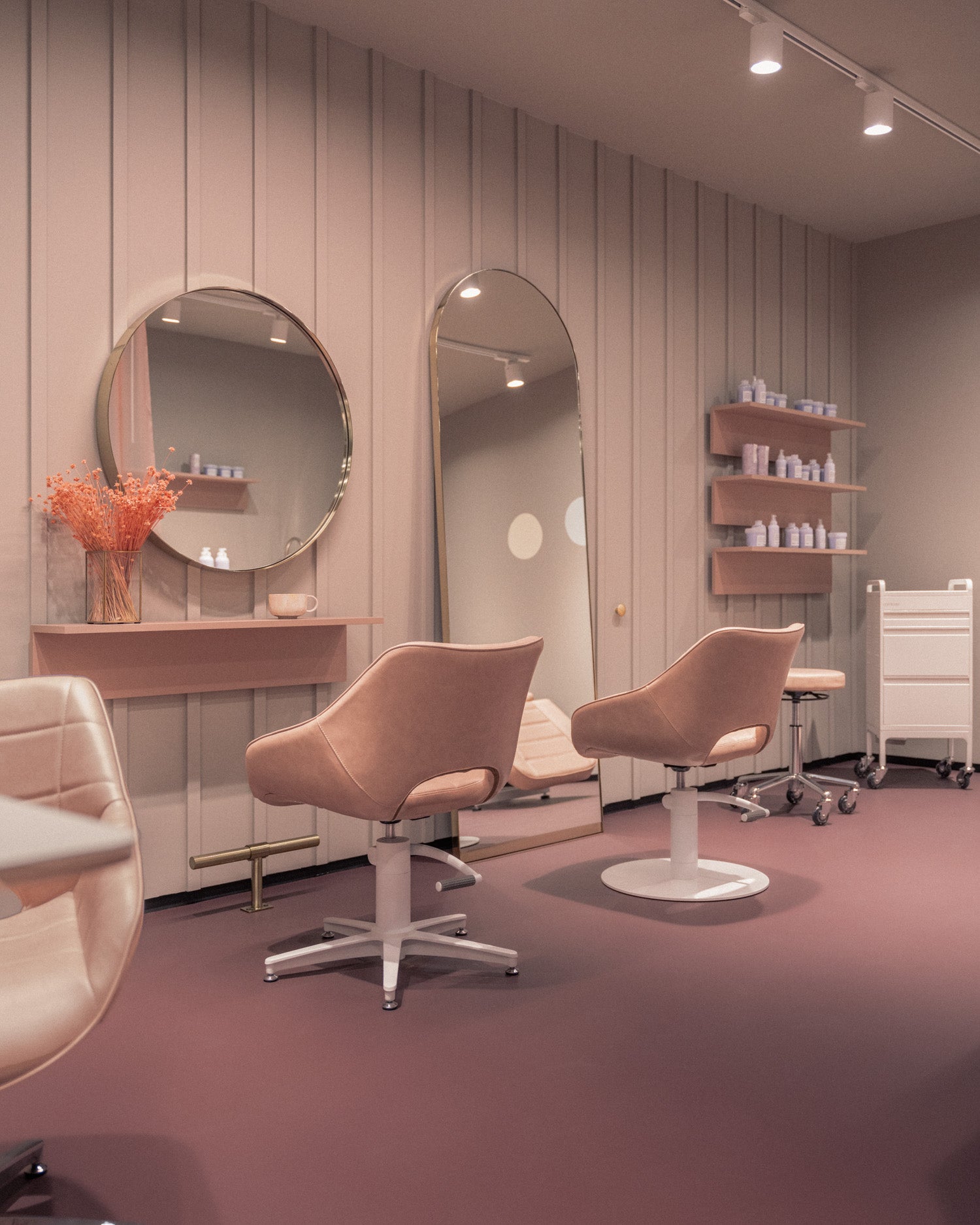 rosie frisørstol i pink salonmiljø. Frisørspejl i messing